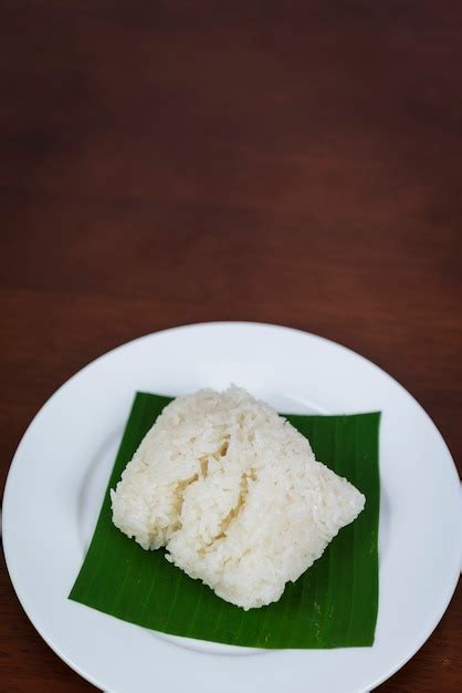 Premium Photo | Sticky rice on banana leaf and wooden background