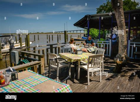 People enjoy the waterfront rustic patio dining at Boss Oyster Restaurant in Apalachicola, FL,on ...