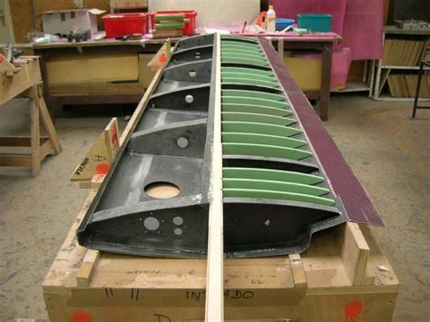 a long row of canoes sitting on top of wooden pallets in a shop