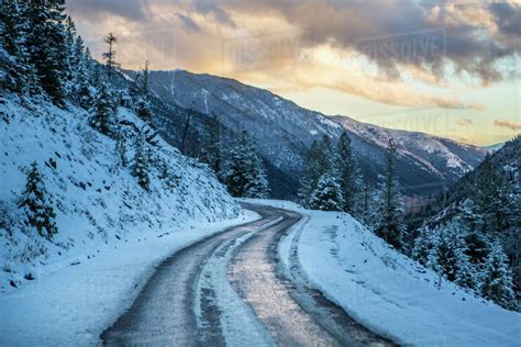 Snow on winding mountain road - Stock Photo - Dissolve