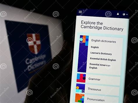 Person Holding Cellphone with Logo of Cambridge Dictionary on Screen in ...