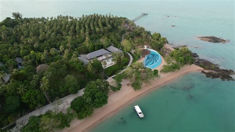 Premium stock video - Luxury resort on a white sand beach island in thailand during sunset, aerial