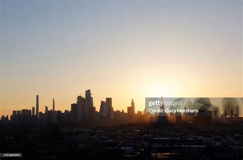 The sun rises behind the Empire State Building and skyline of midtown ...