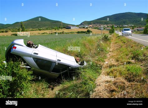 Car crash accident upside down vehicle off the road green landscape Stock Photo - Alamy