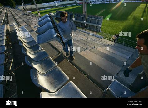 Two men installing seats at a football stadium Stock Photo - Alamy