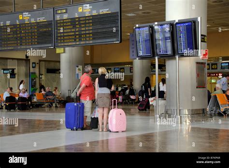 Airport terminal departures board travellers man woman at Reina Sofia ...