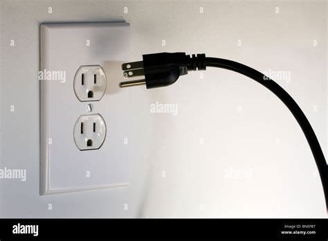 Amerikanische drei Säulen Stecker schwebt vor einer 110 Volt a/c-Steckdose Stockfotografie - Alamy