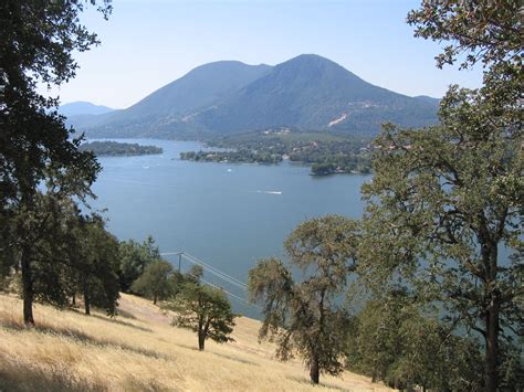 a lake surrounded by trees and mountains in the background