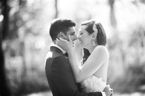 A bride and groom sharing a romantic kiss amidst the enchanting surroundings of the Brooklyn ...