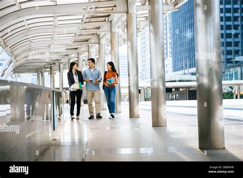 Full length of students friends walking together in college campus Stock Photo - Alamy