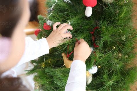 Image of Child's hands decorating Christmas tree - Austockphoto