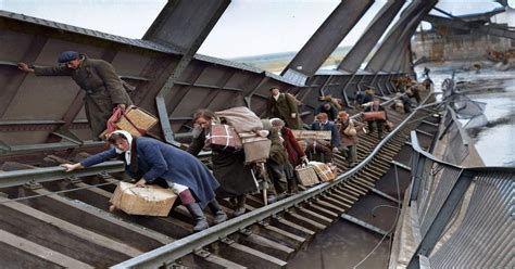 Displaced persons crossing the River Elbe over what is left of the ...