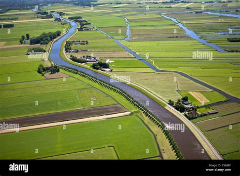 The Netherlands, near De Rijp, Polder with traditional farmland and farms. Belt canal of ...