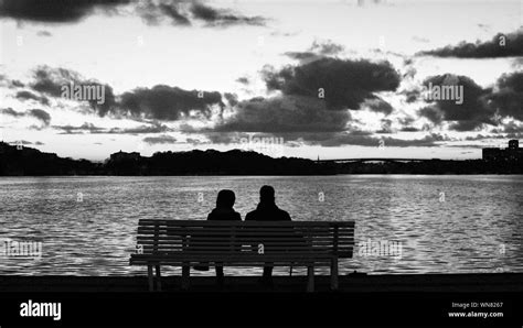 Silhouette couple sitting on bench hi-res stock photography and images - Alamy