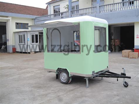 a small green trailer parked in front of a building
