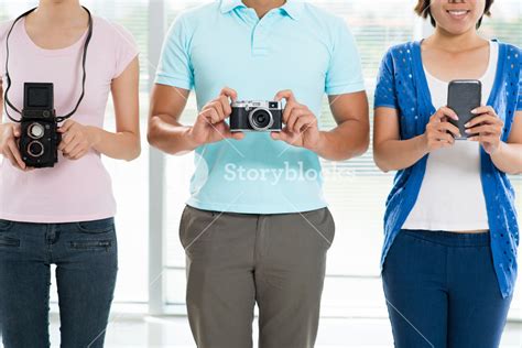 Cropped image of young people with old fashioned cameras and a modern ...