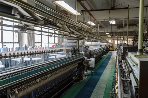 Textile Factory, with Machines Spinning and Weaving Fabric into Diverse ...