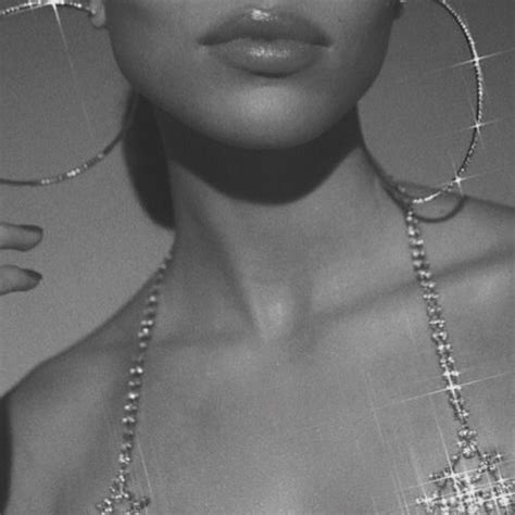 black and white photo of woman wearing large hoop earrings with crystal beads on her neck