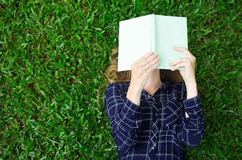 Free Photo | Girl lying on grass and reading book