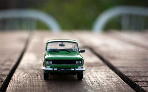 a green toy truck sitting on top of a wooden table