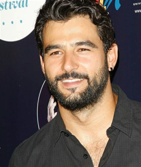 a man with a beard smiling at the camera