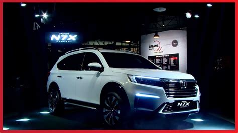 a white suv is on display at an auto show in front of a sign that says n7x