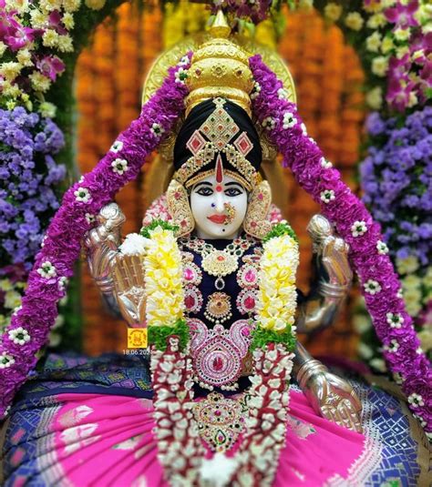 an idol is displayed in front of purple and yellow flowers