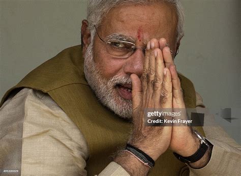 BJP leader Narendra Modi gestures to supporters as he sits with his ...