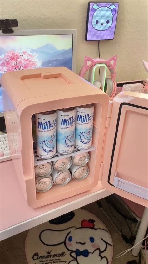 an open pink mini fridge sitting on top of a desk