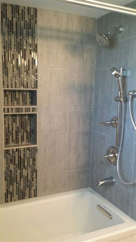 Small alcove shower tub with Malta Gray porcelain tile surround and "Dusk to Dawn" linear glass ...