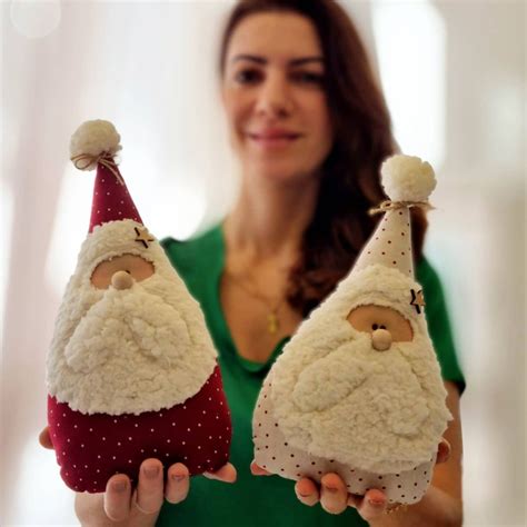 a woman holding two christmas decorations in her hands