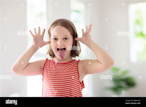 Child making funny face. Kid teasing and laughing. Silly little girl ...