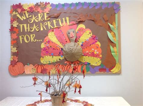 there is a paper turkey on the table with flowers in front of it and a sign that says we are ...