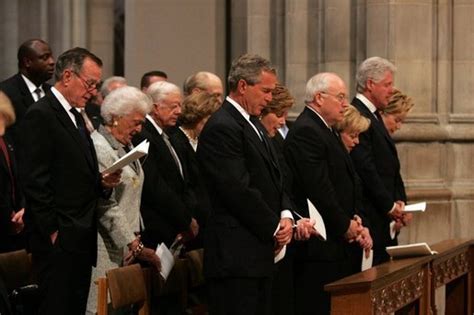 President George W. Bush bows his head during a prayer reading during ...