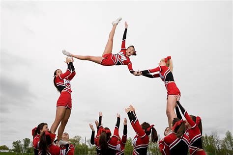 a group of cheerleaders in red and black outfits are doing aerial ...