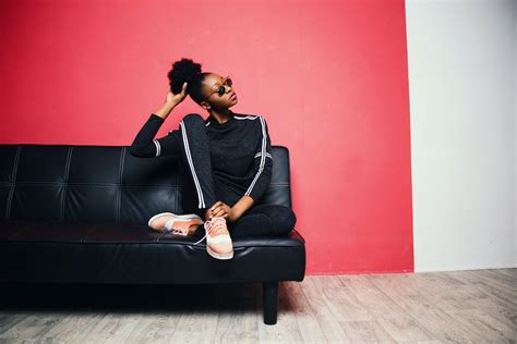 Woman With Black-and-white Sweater With Pants Sitting on Black Leather Sofa Beside Red Painted ...