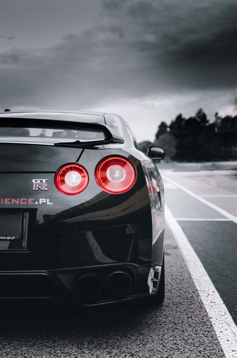 Download Shiny Black Nissan R35 Gtr Dark Clouds Wallpaper | Wallpapers.com