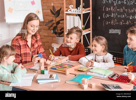 Children with math teacher during lesson in classroom Stock Photo - Alamy