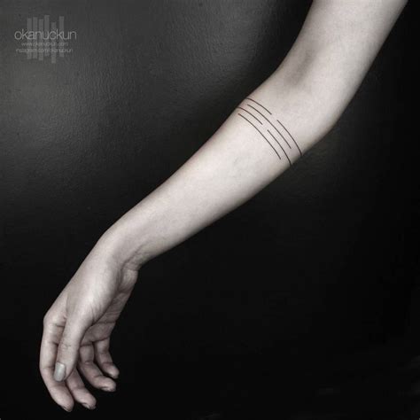 Minimalist armband tattoo on the right forearm.