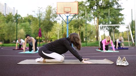 Yoga teacher and yoginis doing poses outdoor 12243471 Stock Video at Vecteezy