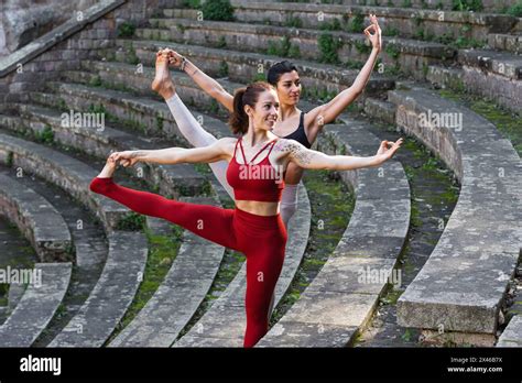 Flexible females in sportswear practicing yoga in Utthita Hasta ...