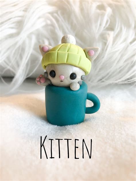 Polymer clay gray kitten wearing a lime green snow hat in a blue-green mug Clay Crafts For Kids ...