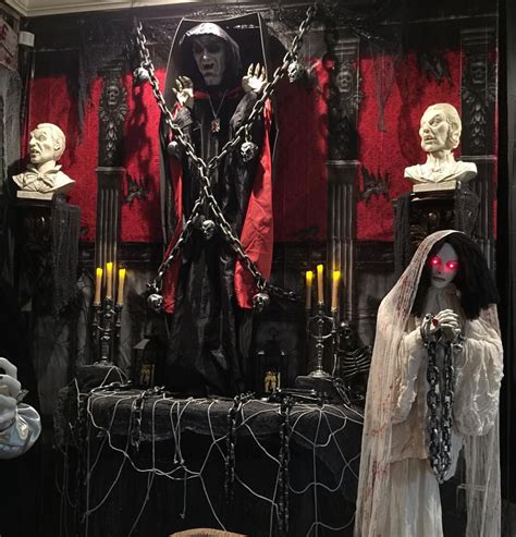 some creepy looking statues in a room with red curtains and lights on ...