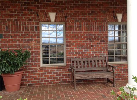 A red brick exterior with contrasting but monochromatic red brick paver porch/patio. Exterior ...