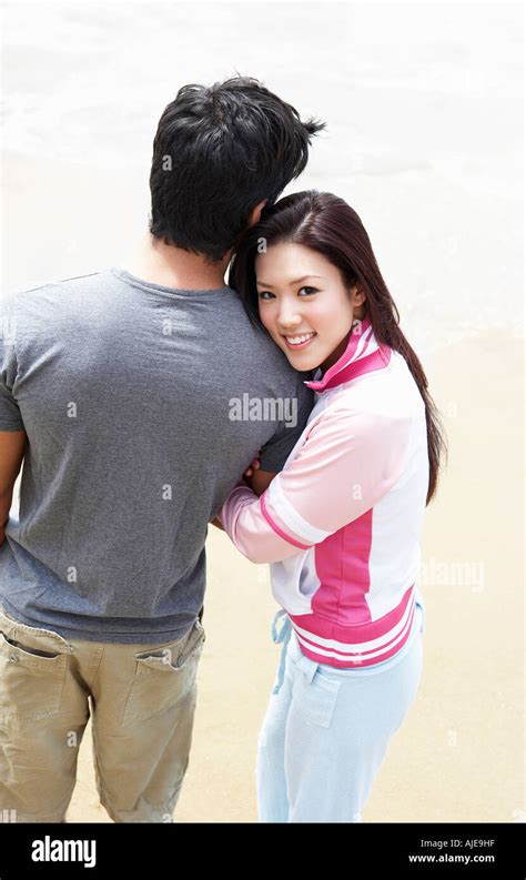 Young couple arm in arm on beach, elevated view Stock Photo - Alamy