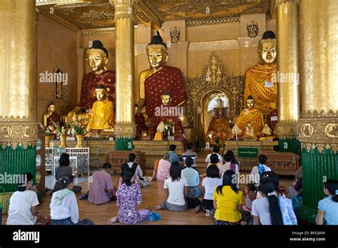 Buddhist devotees worshiping Buddha statues. Temple at Shwedagon Paya. Yangon. Myanmar Stock ...