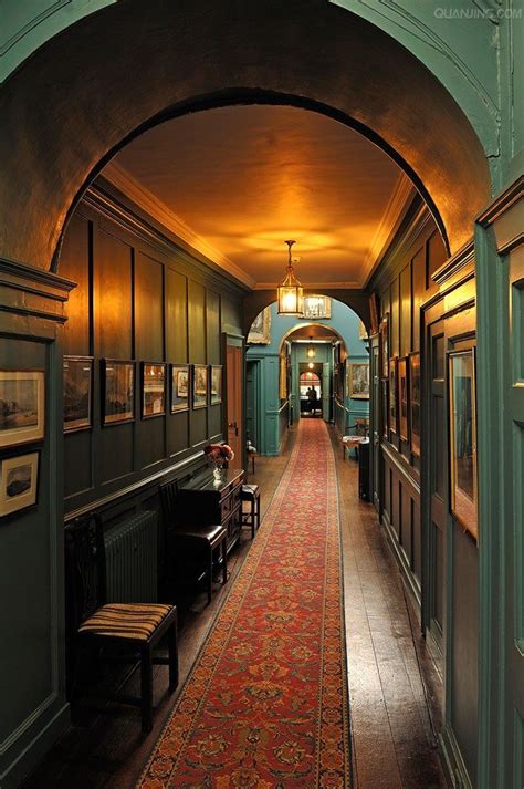 the hallway is lined with antique furniture and framed pictures on the walls, along with an ...