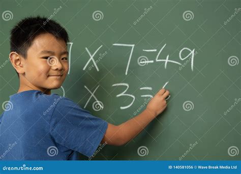 Schoolboy Doing Math on Greenboard in a Classroom Stock Photo - Image of attentive, education ...