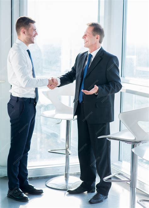 Premium Photo | Two happy male business partners shaking hands in office