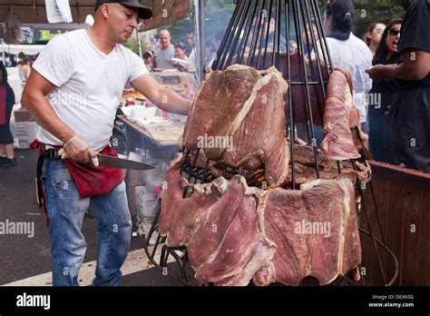 Man cooking beef steaks on a large hanging barbecue grill -USA Stock ...